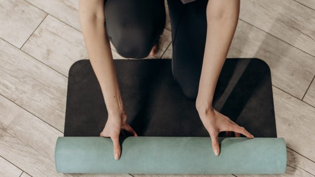 Woman rolling out yoga mat