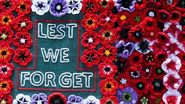 Knotted poppies and 'Lest we forget' text