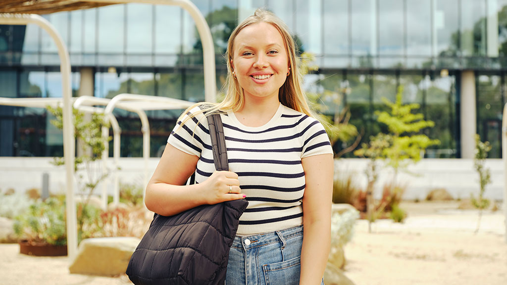 Smiling young woman outside at campus