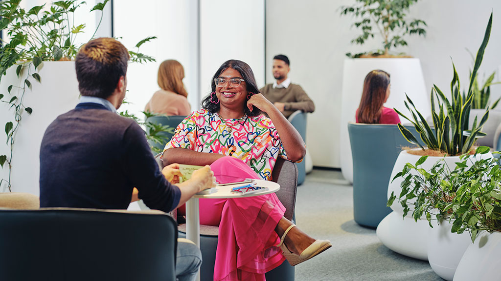 Various groups of people seated in communal work space