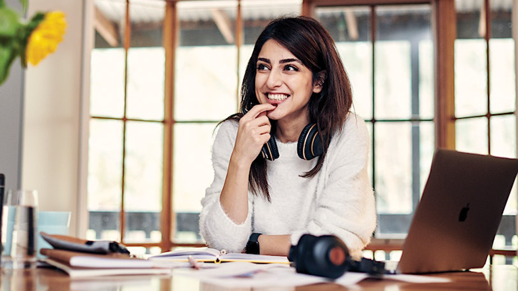 A student sitting smiling at a desk