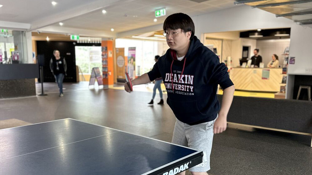 Student playing table tennis in DUSA Lounge