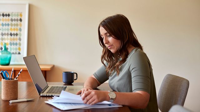 Female sitting at desk with laptop and notebook