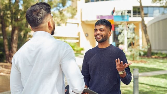 Two male international students chatting on campus