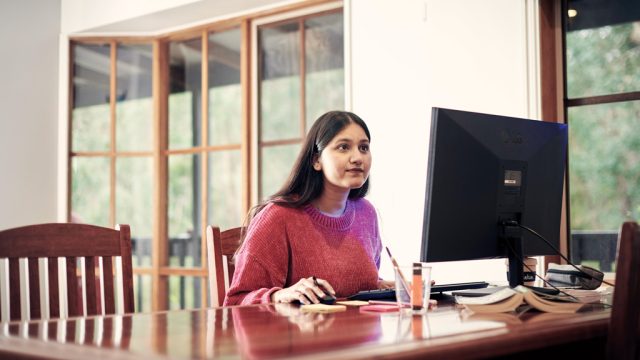 Student looking at PC at home desk