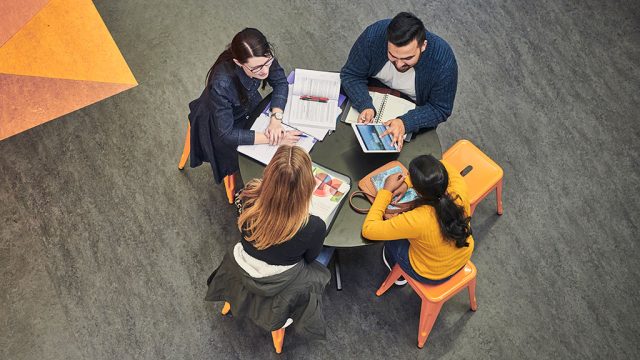 Aerial view of four students at table working