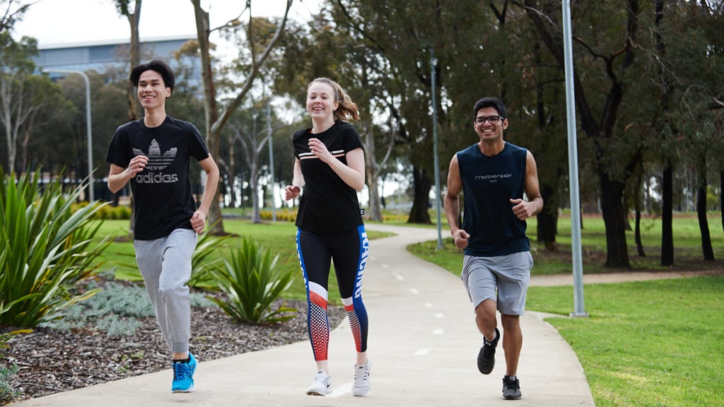 Three students jogging through Waurn Ponds Campus