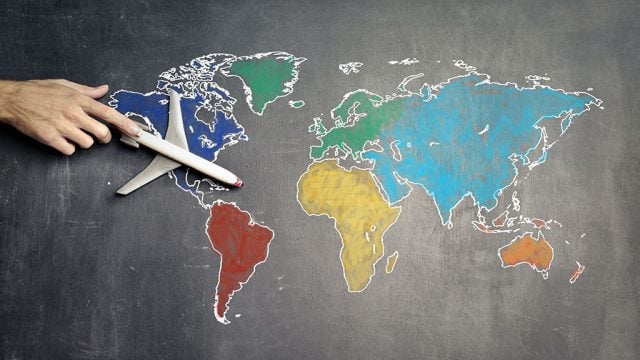 Model plane sitting on hand-drawn map of the world