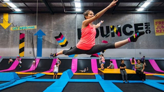 Young woman doing splits in air at Bounce