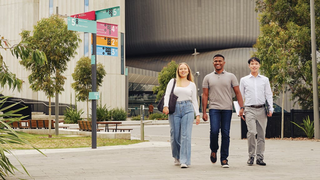 Three friends walk together outside at Burwood Campus