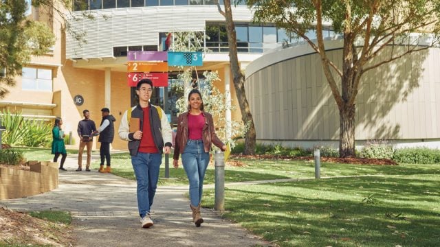 Two students smiling as they walk through Waurn Ponds Campus