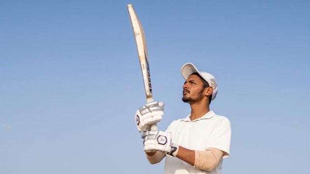 Cricketer holding up a bat