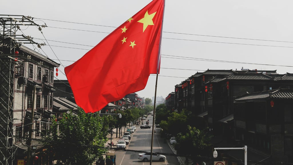 Chinese flag above cityscape