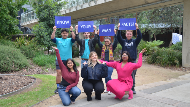 Wellbeing Ambassadors and students with men's Health Week 2024 'Know Your Man Facts' placards