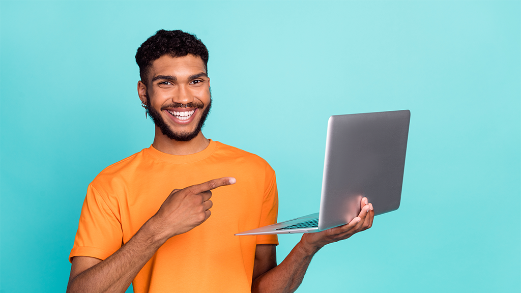 A student pointing at a laptop.