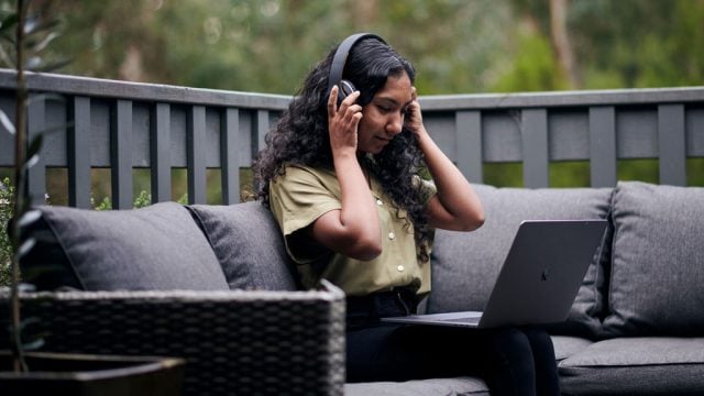 Student working on laptop with headphones