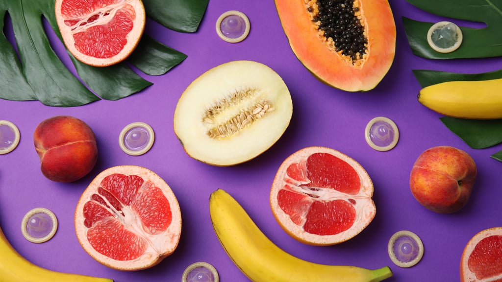 Various fruit and condoms arranged on bright background