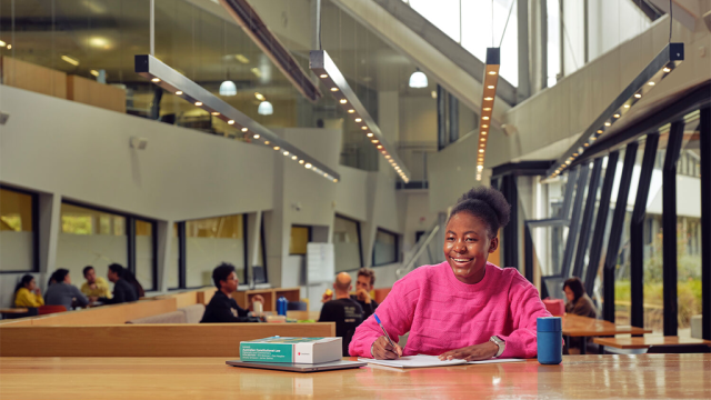 A student sitting at a desk smiling