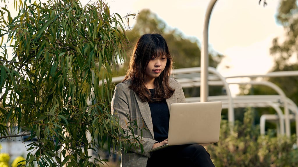 Student working on laptop outside