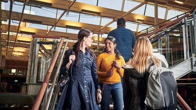 Students walking down stairs and chatting at Waterfront Campus