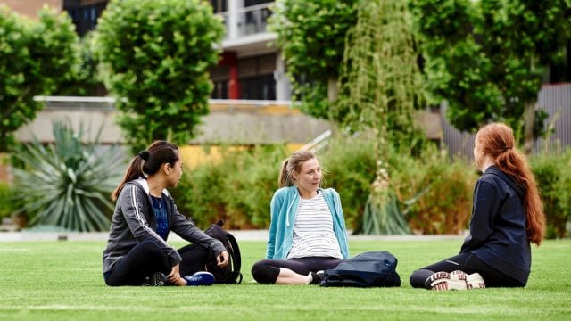 Three students sitting on the lawn at Waurn Ponds Campus