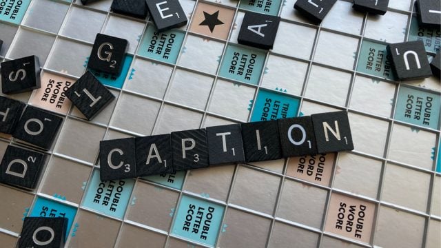 Scrabble tiles spelling out the word 'caption'.