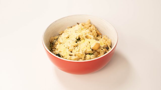 Bowl of chicken risotto, topped with Parmesan cheese.